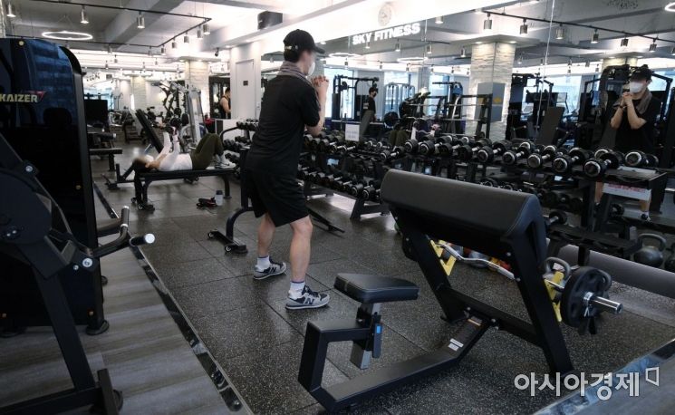 수도권 실내 체육시설 운영이 재개된 18일 서울의 한 헬스장에서 시민들이 운동을 하고 있다. 방역당국은 수도권의 카페와 실내 체육시설, 노래 연습장 등의 다중 이용시설에 대한 사회적 거리두기 조치 일부를 완화했다. 이날부터 카페는 밤 9시까지 매장 내 취식이 가능하고 헬스장은 8㎡당이용 인원 1명으로 제한해 운영할 수 있다./김현민 기자 kimhyun81@