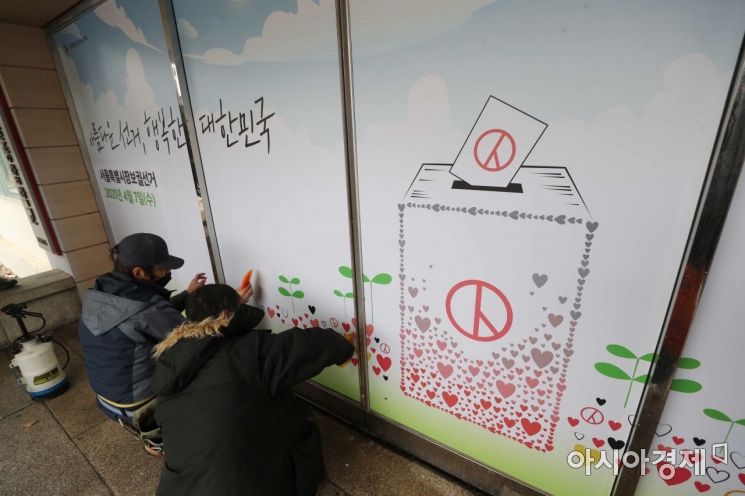 서울시장 보궐선거가 80일 앞으로 다가온 18일 서울 종로구 서울시선거관리위원회에서 관계자들이 출입구에 '아름다운 선거, 행복한 대한민국' 문구가 적힌 홍보물을 붙이고 있다. /문호남 기자 munonam@