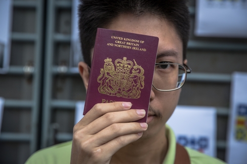 한 홍콩 민주화 시위 지지자가 영국해외시민(BNO) 여권을 들어보이고 있다.   [이미지 출처= EPA연합뉴스]