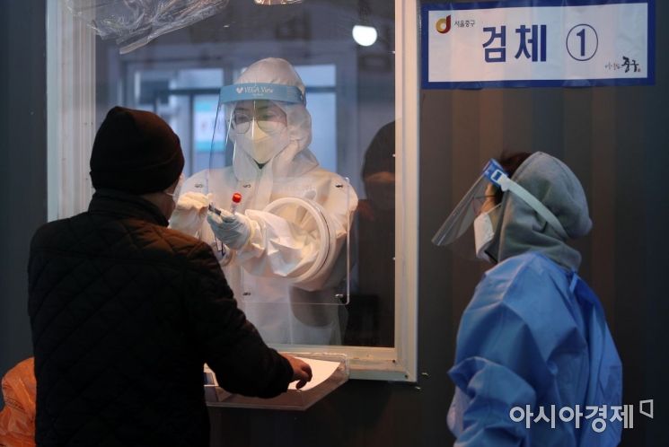 국내 코로나19 신규 확진자수가 닷새 만에 300명 대로 내려간 31일 서울역 임시 선별검사소에서 의료진이 검체 채취를 하고 있다. 이날 중앙방역대책본부에 따르면 이날 0시 기준 신규 확진자는 355명으로 집계됐다. 국내 발생 확진자는 325명, 해외 유입 확진자는 30명이며 총 누적 확진자는 7만8205명이다./김현민 기자 kimhyun81@
