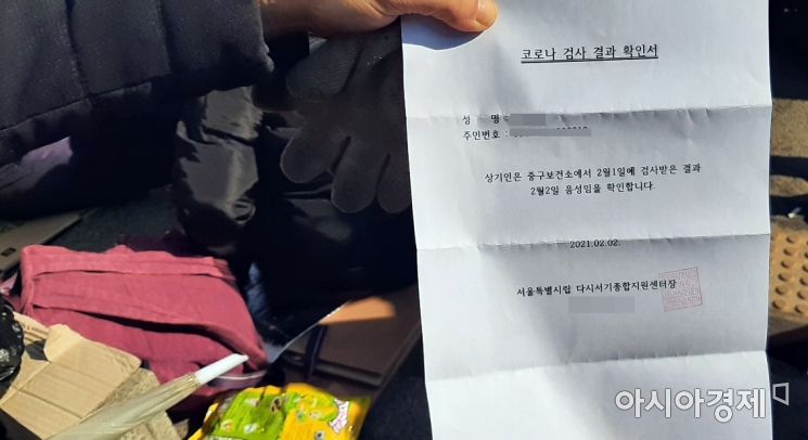 한 노숙인이 코로나19 음성 판정 결과서를 취재진에 보이고 있다. 대부분의 노숙인은 수 차례 코로나 검사를 받아 시민들이 우려하는 코로나19 확산 위험이 없다고 강조했다. 사진=한승곤 기자 hsg@asiae.co.kr