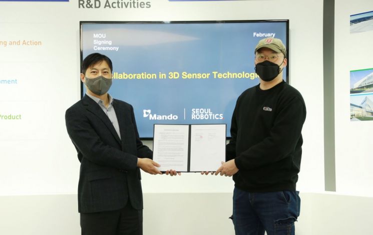 강형진 만도 ADAS BU R&D센터장(왼쪽)과 이한빈 서울로보틱스 대표가 경기 성남시에 있는 판교 만도 R&D센터에서 MOU 체결 후 기념촬영을 하고 있다..