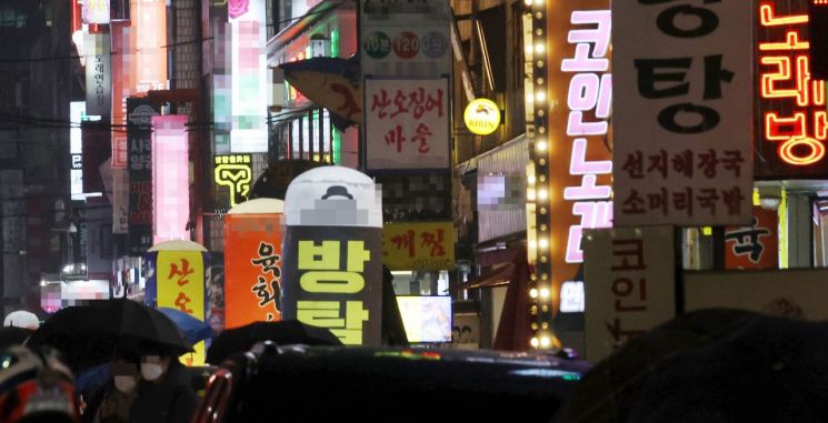 유흥시설들이 들어선 서울 송파구 잠실새내역 인근 거리에 밤 9시가 넘어 간판 불을 밝힌 업소들 사이로 시민들이 귀가하고 있다. [이미지출처=연합뉴스]