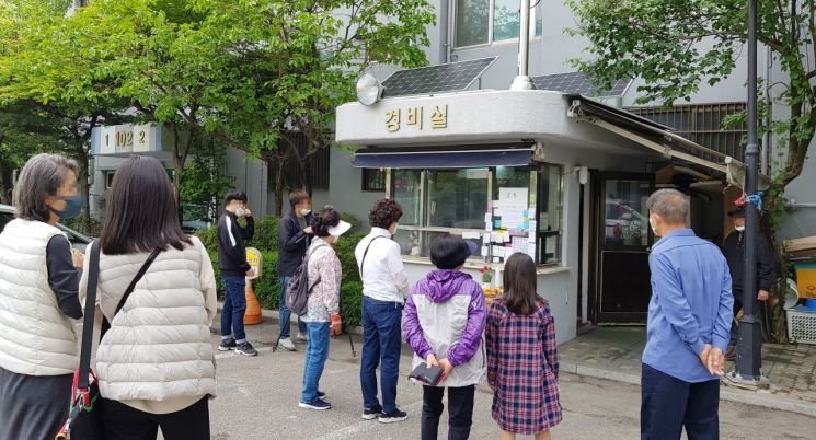 서울 강북구 우이동의 한 아파트에서 극단적 선택을 한 아파트 경비원을 추모하기 위해 주민들이 고인이 생전 생전에 근무하던 경비 초소에 마련된 분향소에 모여있다. 사진은 지난해 5월11일 촬영된 분향소 앞에 모여든 주민들. [이미지출처=연합뉴스]