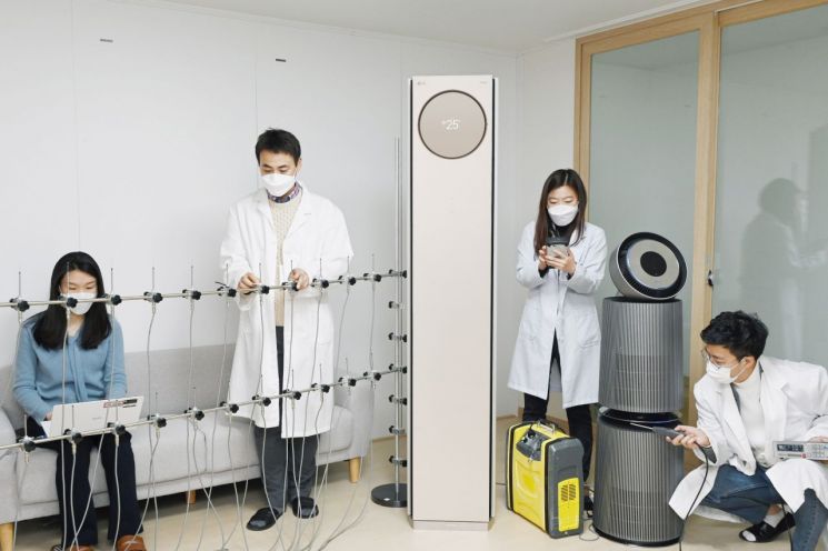 LG전자 연구원들이 서울 금천구 가산R&D캠퍼스에 위치한 공기과학연구소에서 휘센 타워 에어컨의 기류(氣流), 퓨리케어 360˚ 공기청정기 알파의 미세먼지제거능력 등을 시험하고 있다.[사진=LG전자 제공]