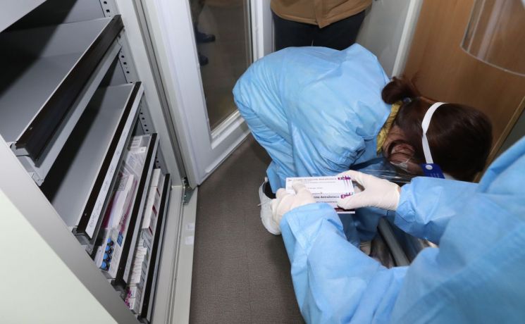 코로나19 아스트라제네카(AZ) 백신 접종을 하루 앞둔 25일 오전 서울 성동구보건소에서 방역 관계자들이 AZ백신을 백신 냉장고에 옮기고 있다. [이미지출처=연합뉴스]