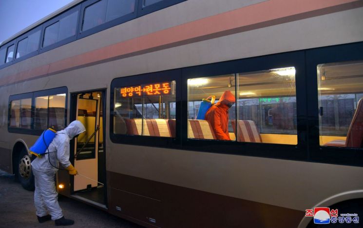 북한의 모란봉버스사업소가 코로나19 방역을 위해 버스 안팎 소독하고 있다./사진=조선중앙통신, 연합뉴스