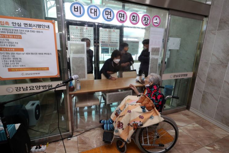 광주 동구 강남요양병원에서 90대 입원 환자와 자식, 며느리가 투명 가림막을 사이에 두고 비대면 면회를 하고 있다. [이미지출처=연합뉴스]