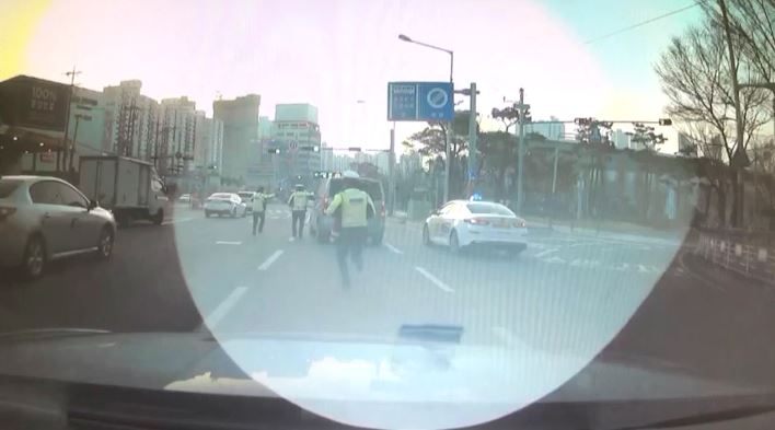 부산 해운대구 우동 도로에 멈췄던 스타렉스 차량이 경찰의 검문에 불응하고 도주하자 경찰들이 뒤쫓고 있다. [이미지출처=부산경찰청]