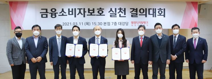 김대웅 대표이사(왼쪽에서 5번째)가 웰컴저축은행 임직원과 금융소비자보호 실천 결의대회 후 결의서 내용을 들고 기념사진을 촬영하고 있다.