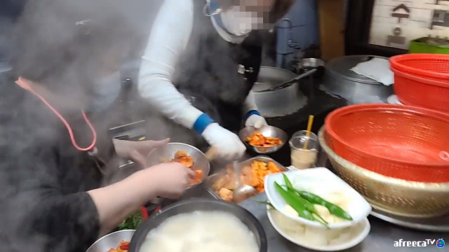 BJ파이 영상에 포착된 잔반 재사용 장면. 왼쪽 직원은 손님이 먹다 남은 깍두기를 반찬통 담고 있고, 오른쪽 직원은 반찬통에서 깍두기를 덜어 새 그릇에 담고 있다. 사진= 아프리카TV BJ파이 방송화면 캡처