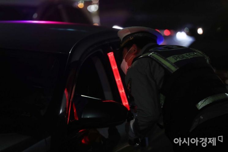 25일 밤 서울 서초 IC 부산방면 진입로에서 경찰이 비접촉 음주감지기로 음주운전 단속을 하고 있다. /문호남 기자 munonam@