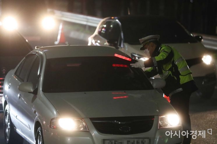 25일 밤 서울 서초 IC 부산방면 진입로에서 경찰이 비접촉 음주감지기로 음주운전 단속을 하고 있다. /문호남 기자 munonam@