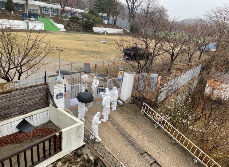 27일 코로나19 환자가 무더기로 나온 인천시 강화군 길상면 폐교에서 내부에 있던 환자들이 병원으로 이동하기 위해 우산을 쓰고 교문을 나서고 있다. 강화군은 이곳과 인근 상가 건물에서 합숙 생활을 하는 정수기 방문판매 업체 종사자 등 29명이 양성 판정을 받았다고 이날 밝혔다. [이미지출처=연합뉴스]