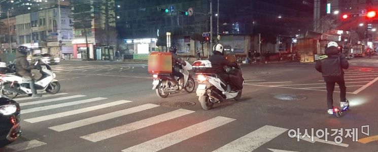배달원들이 횡단보도를 넘어 신호를 기다리고 있다. 사진=한승곤 기자 hsg@asiae.co.kr