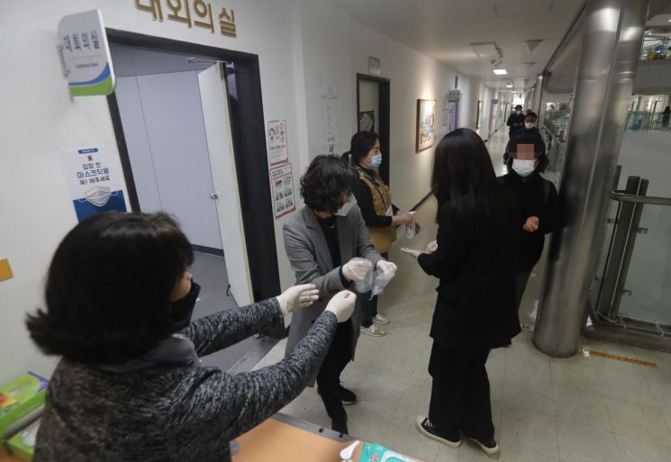 4·7 재·보궐선거 사전투표 첫날인 2일 오전 부산 연제구청에 마련된 투표소에서 시민들이 위생장갑을 배부받고 있다. [이미지출처=연합뉴스]