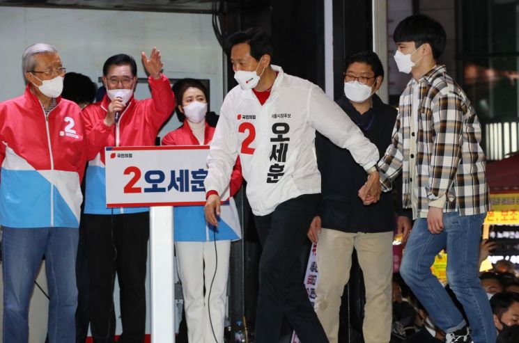 오세훈 국민의힘 서울시장 후보가 6일 서울 서대문구 신촌거리에서 열린 마지막 거리유세에서 지지 연설에 나선 한 청년의 손을 잡고 무대에 오르고 있다. / 사진=연합뉴스