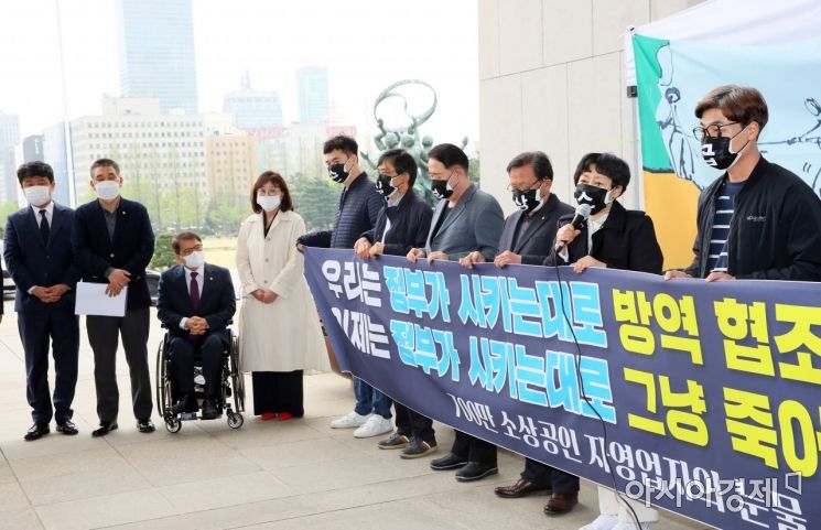 최승재 의원 등 국민의힘 의원들이 12일 국회 본청 앞에서 소상공인 자영업자들과 함께 코로나19에 따른 손실보상 소급적용 입법을 요구하며 기자회견하고 있다./윤동주 기자 doso7@