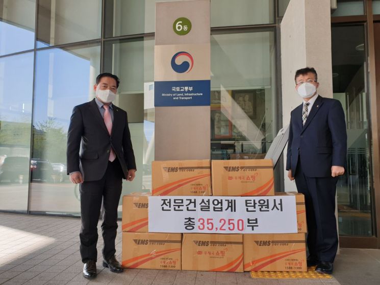 전건협 김영현 건설정책본부장(왼쪽)과 김문중 건설정책실장이 전문건설업계 탄원서를 국토부에 제출하고 있다.