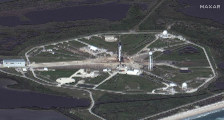 미국 우주 탐사기업 스페이스X의 유인 우주선 크루 드래건을 탑재한 팰컨9 로켓이 22일(현지시간) 발사를 하루 앞두고 플로리다주 케이프커내버럴의 케네디우주센터 39A 발사대에서 대기하는 모습을 위성으로 촬영한 사진. 이번에 발사되는 크루 드래건과 로켓은 스페이스X가 처음으로 재활용했다. 우주 비행사 4명을 국제우주정거장(ISS)으로 보내기 위한 이번 크루-2 임무는 기상악화로 발사 일정이 23일로 하루 늦춰졌다. (사진=AFP.연합) [이미지출처=연합뉴스]