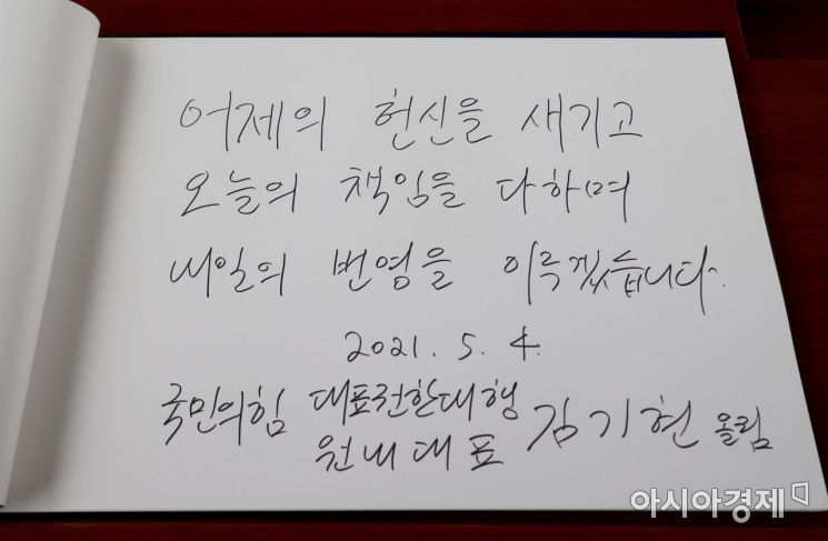 김기현 국민의힘 당대표 권한대행 겸 원내대표가 4일 서울 동작구 국립서울현충원 현충탑에서 참배 후 방명록을 남기고 있다./국회사진기자단