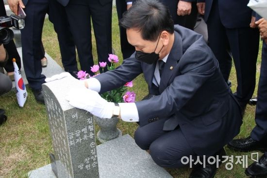 김기현 국민의힘 원내대표 권한대행이 7일 국립5.18민주묘지 행방불명자 묘역에서 묘비를 어루만지고 있다.