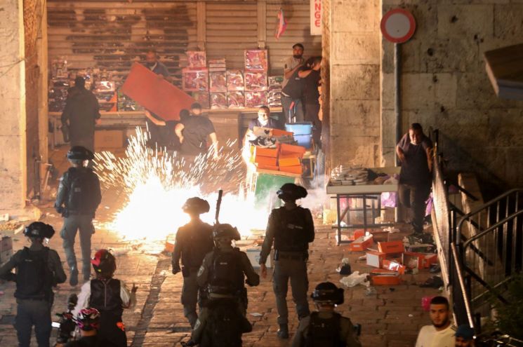 9일(현지시간) 이스라엘 예루살렘에서 팔레스타인 주민들의 시위가 열린 가운데 경찰이 시위대를 향해 섬광탄을 발사하고 있다. [이미지출처=로이터연합뉴스]
