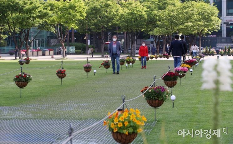 [포토] 서울광장 꽃길 지나는 출근길 시민들