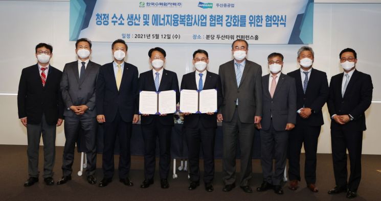12일 분당두산타워에서 열린 '청정수소 생산 및 에너지 융복합사업 협력 강화를 위한 협약식'에서 한국수력원자력 김상돈 성장사업본부장(왼쪽 4번째)과 두산중공업 정연인 사장(왼쪽 5번째)이 서명을 마친 후 관계자들과 기념촬영을 하고 있다.(사진제공=두산중공업)