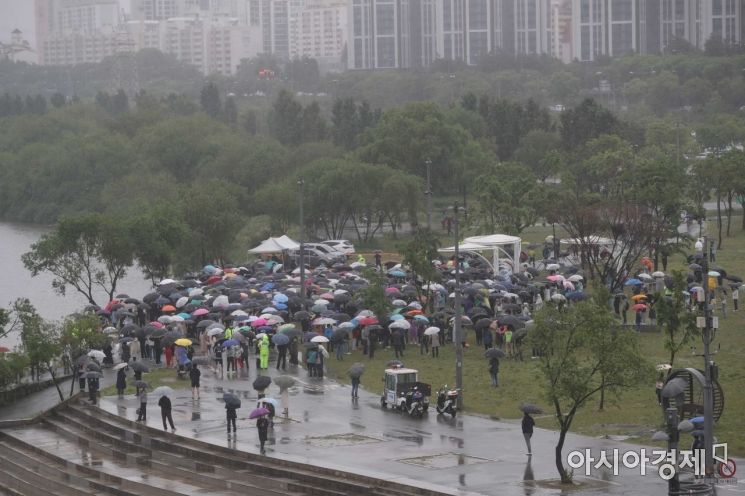 전국에 비가 내린 16일 서울 반포한강공원 수상택시 승강장 인근에서 열린 '고 손정민 군을 위한 평화집회'에서 참가자들이 우산을 쓴 채 사건의 진상규명을 촉구하고 있다. /문호남 기자 munonam@