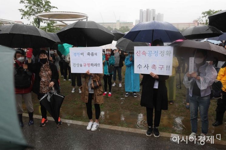 지난 16일 서울 반포한강공원 수상택시 승강장 인근에서 열린 '고 손정민 군을 위한 평화집회'에서 참가자들이 우산을 쓴 채 사건의 진상규명을 촉구하고 있다.