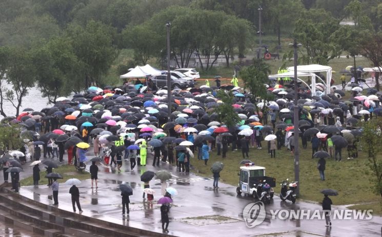 16일 오후 서울 반포한강공원 수상택시 승강장 인근에서 열린 '고 손정민 군을 위한 평화집회'에서 참가자들이 우산을 쓴 채 자리를 지키고 있다. / 사진=연합뉴스