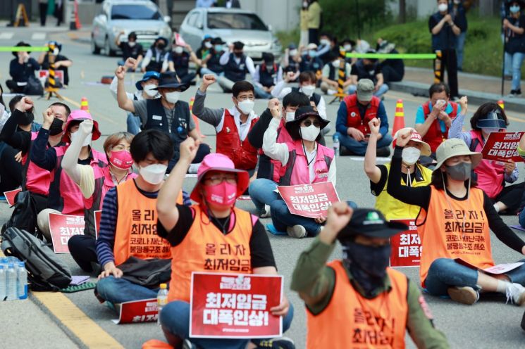 민주노총 조합원들이 18일 오후 최저임금위원회 전원회의가 열리는 정부세종청사 고용노동부 앞에서 공익위원 유임을 규탄하고 최저임금 인상을 촉구하는 결의대회를 열었다.(이미지 출처=연합뉴스)