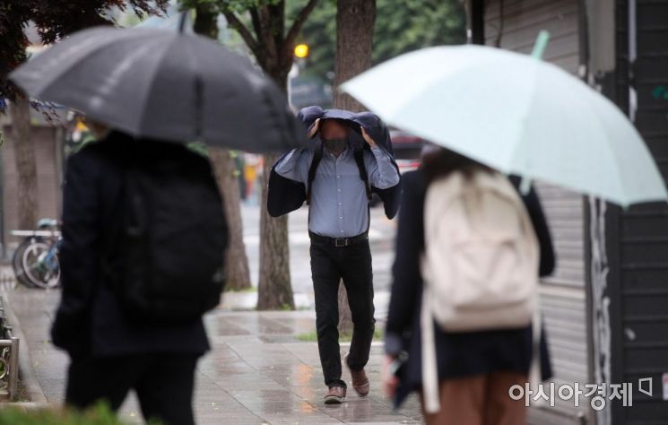 중부지방 곳곳에 비가 내린 1일 서울 광화문 인근 거리에서 우산을 준비하지 못한 한 출근길 시민이 겉옷을 덮어쓰고 발걸음을 재촉하고 있다./김현민 기자 kimhyun81@