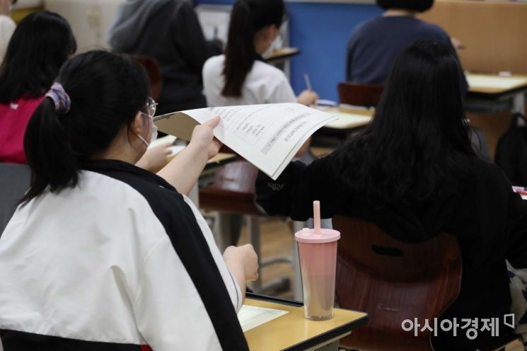문·이과 통합 체제로 시행되는 2022학년도 대학수학능력시험의 첫 모의평가가 실시된 3일 서울 영등포구 여의도여자고등학교에서 학생들이 시험지를 받고 있다.