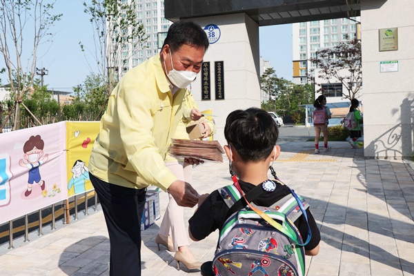 김산 군수가  오룡 행복초등학교를 방문해 등교하는 학생들에게 마스크와 스티커 형 체온계를 배부하는 안전한 등교 맞이 캠페인을 진행했다. (사진=무안군 제공)