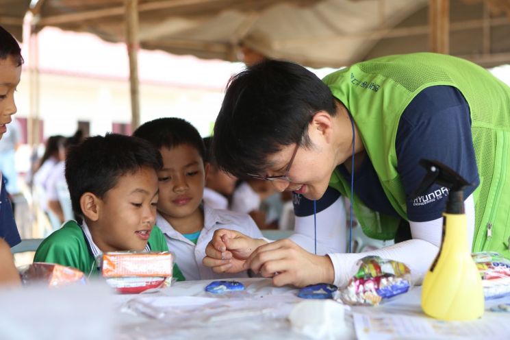 현대엔지니어링이 기증한 라오스 '새희망학교 9호'와 글로벌임직원봉사단 모습.