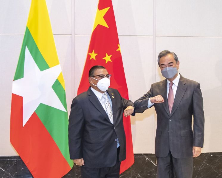 8일 중국 쓰촨성 충칭시에서 열린 중국-아세안(ASEAN) 특별외교장관회의에 참석한 중국 왕이 외교부장(오른쪽)이 운나 마웅 르윈(왼쪽) 미얀마 외무장관과 팔꿈치 인사를 하고 있다. 중국은 이번 회의에 미얀마 군부가 임명한 외무장관을 초청해 군부를 옹호한다는 비판을 받았다. 충칭(중국)= 신화·연합뉴스