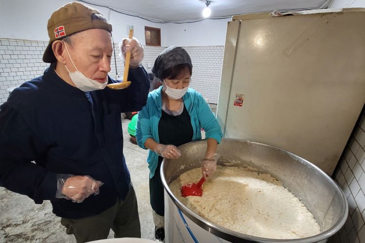 술을 거르기 앞서 최종 점검을 하고 있는 부부