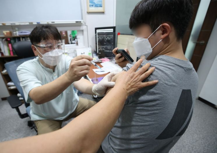 한 시민이 얀센 백신을 접종받으며 휴대전화로 인증샷을 찍고 있다. / 사진=연합뉴스