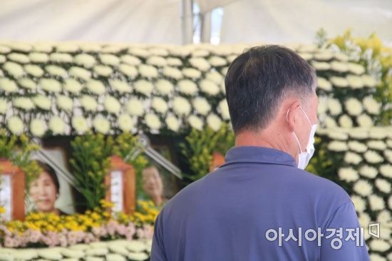 광주광역시 동구 학동 재개발지역 내 건물 붕괴로 인한 희생자들을 추모하기 위해 동구청 주차장에 설치된 분향소에 13일 오전 한 시민이 분향을 한 뒤 말없이 영정사진을 바라보고 있다.