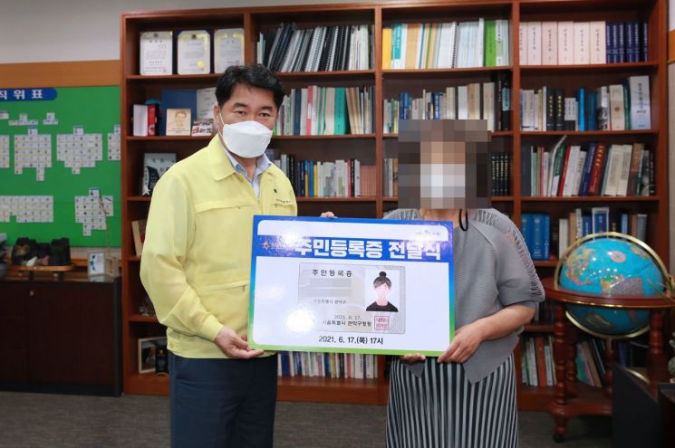 박준희 구청장(왼쪽)이 17일 오후 A씨에게 주민등록증을 전달하고 있다.