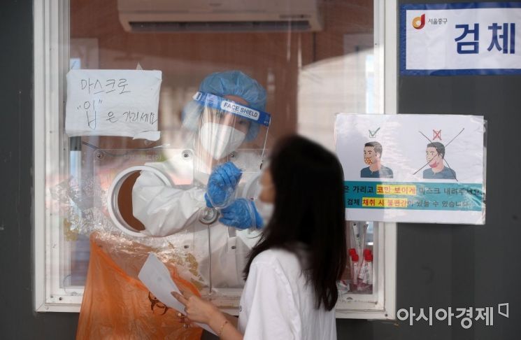 지난 20일 서울역 광장에 마련된 임시 선별검사소에서 의료진이 시민의 검체를 채취하고 있다./김현민 기자 kimhyun81@