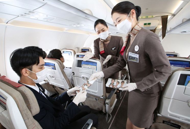 아시아나항공 대학생 승무원 체험 비행에 참여한 학생이 항공기 기내에서 유니세프 모금 안내 실습을 하고 있다.