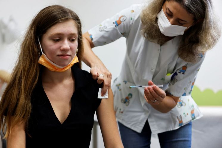 이스라엘이 델타 변이 확산으로 비상인 가운데 지난 21일(현지시간) 텔아비브에서 한 10대 소녀가 코로나19 백신을 맞고 있다. [이미지출처=연합뉴스]