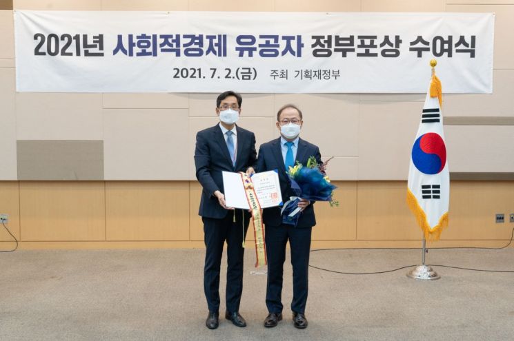 이상학 KT&G 지속경영본부장(오른쪽)이 지난 2일 2021 사회적경제 유공자 정부포상 수여식에서 대통령 표창을 수상하고 기념사진을 찍고 있다. (사진제공=KT&G)