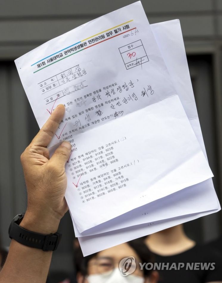 지난 7일 '서울대학교 청소 노동자 조합원 사망 관련 오세정 총장 규탄 기자회견'에서 민주노총 조합원이 청소 노동자가 본 시험지를 들어 보이고 있다. /사진=연합뉴스
