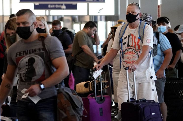 지난 2일(현지시간) 시카고 오헤어 국제공항에서 관광객들이 마스크를 쓰고 수속 절차를 위해 줄을 서서 기다리고 있다. [이미지출처=AP연합뉴스]