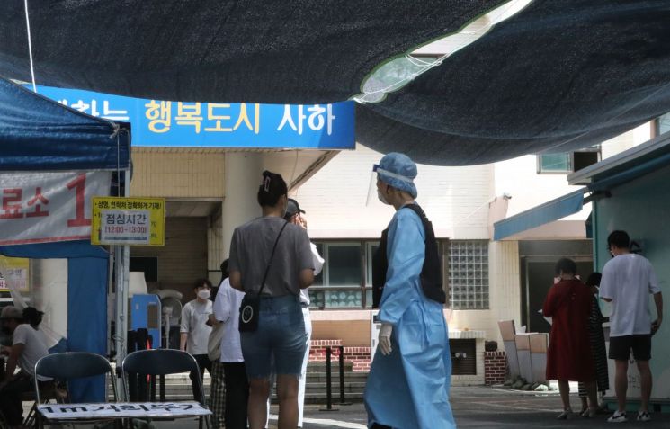 지난 13일 부산 사하구보건소 선별진료소에서 시민들이 코로나19 검사를 받기 위해 순서를 기다리고 있다. [이미지출처=연합뉴스]