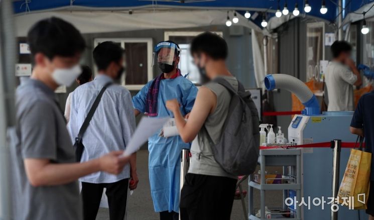국내 코로나19 대규모 확산세가 이어진 18일 서울역 임시선별검사소에서 의료진이 시민들을 안내하고 있다. 중앙방역대책본부에 따르면 이날 0시 기준 신규 확진자는 1454명 늘어 주말 기준으로 가장 많은 수치를 나타냈다. 지난 7일 1212명부터 12일 연속 네 자릿수를 기록했다./김현민 기자 kimhyun81@